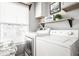 Well-lit laundry room boasting a modern washer and dryer set with upper cabinets and shelving at 2251 N New Jersey St, Indianapolis, IN 46205