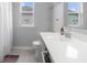 Bright bathroom featuring a vanity with white countertop, dual windows and tile flooring at 2396 Creek Bank Dr, Columbus, IN 47201