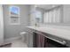 Well-lit bathroom showcasing a vanity with grey cabinetry, dual windows and tile flooring at 2396 Creek Bank Dr, Columbus, IN 47201