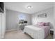 Bright bedroom with a desk, closet, and bed dressed in white and mauve bedding at 2396 Creek Bank Dr, Columbus, IN 47201