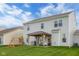 Rear exterior view of a two-story home with a covered patio, swing set, and spacious lawn at 2396 Creek Bank Dr, Columbus, IN 47201