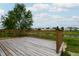 An outdoor back deck overlooks a scenic pond and lush green lawn at 2449 Orchard Creek Dr, Columbus, IN 47201