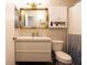 Bright bathroom with a white vanity, a decorative gold mirror and a shower with a white and blue curtain at 2449 Orchard Creek Dr, Columbus, IN 47201