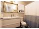 Well-lit bathroom with a stylish vanity, a decorative mirror and a shower with a blue and white curtain at 2449 Orchard Creek Dr, Columbus, IN 47201