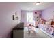 Brightly painted purple bedroom with cute decor, rug, and carpet flooring at 2449 Orchard Creek Dr, Columbus, IN 47201