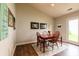 Dining room with wood table, chairs, wood floors, light-colored rug, and artwork on the walls with a door to the exterior at 2449 Orchard Creek Dr, Columbus, IN 47201