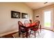 Dining room with a wood table, wooden chairs, dark brown floors, a light-colored rug, and artwork adorning the walls at 2449 Orchard Creek Dr, Columbus, IN 47201