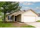 Inviting single-Gathering home with tan siding, attached garage, manicured lawn, and a mature tree providing shade at 2449 Orchard Creek Dr, Columbus, IN 47201