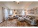 Spacious living room with a plush sectional, area rug, lots of art, and large windows providing ample natural light at 2449 Orchard Creek Dr, Columbus, IN 47201