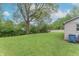 Large, grassy backyard with mature trees, partially fenced in, offering a private outdoor space at 2539 S Lyons Ave, Indianapolis, IN 46241