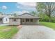 Charming ranch-style house with a gravel driveway, inviting front porch, and colorful flower beds at 2539 S Lyons Ave, Indianapolis, IN 46241