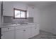 A well-lit kitchen features white cabinets, marble countertops, and a unique wooden window frame at 2539 S Lyons Ave, Indianapolis, IN 46241