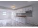 Bright kitchen boasts white cabinets, gray backsplash, and wood countertop, complemented by marble-style tiled floor at 2539 S Lyons Ave, Indianapolis, IN 46241