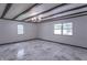Stylish living room featuring marble flooring, beamed ceilings, brick accents, and two bright windows at 2539 S Lyons Ave, Indianapolis, IN 46241