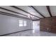 Bright, spacious living room featuring wood beam ceilings, brick accents, and luxury tile flooring at 2539 S Lyons Ave, Indianapolis, IN 46241