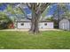 Large backyard with lush green grass, mature trees, and a white brick home at 2706 Shakespeare Dr, Indianapolis, IN 46227
