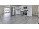 Open kitchen featuring new stainless steel appliances, white cabinets and grey wood-look vinyl flooring at 2706 Shakespeare Dr, Indianapolis, IN 46227