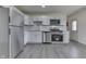 Bright kitchen with new stainless steel appliances, white cabinets, and new grey flooring at 2706 Shakespeare Dr, Indianapolis, IN 46227