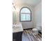 A well-lit bathroom featuring a toilet, wood-style flooring and an arched window with natural light at 2985 Little Hurricane Rd, Martinsville, IN 46151