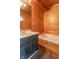 A cozy bathroom with a built-in hot tub, vanity and mirror, wood paneling, and slate-look flooring at 2985 Little Hurricane Rd, Martinsville, IN 46151