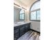 Bathroom features a double vanity sink, arched window, stylish wood floor and updated fixtures at 2985 Little Hurricane Rd, Martinsville, IN 46151