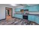 An angled view of a kitchen with light blue cabinets, gray countertop, and stainless steel appliances at 2985 Little Hurricane Rd, Martinsville, IN 46151