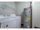 Laundry area with a washing machine, dryer, water heater, and wire rack shelving at 2985 Little Hurricane Rd, Martinsville, IN 46151