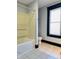 Functional bathroom with a shower-tub combination, white toilet, and a patterned window at 301 N Main St, Franklin, IN 46131