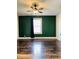 Spacious bedroom with a ceiling fan, a green wall, and a window with a black curtain at 301 N Main St, Franklin, IN 46131