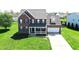 Aerial view of a two-story brick home featuring a welcoming front porch and a two-car garage at 3101 Woodhaven Way, Bargersville, IN 46106