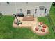 Aerial view of backyard with patio, fire pit, deck, and manicured lawn at 3101 Woodhaven Way, Bargersville, IN 46106