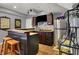 Basement bar area with wooden counter, seating, and stainless steel refrigerator for entertaining at 3101 Woodhaven Way, Bargersville, IN 46106