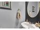 Chic powder room features a pedestal sink, round mirror, and modern fixtures at 3101 Woodhaven Way, Bargersville, IN 46106