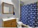 Bathroom features a shower with blue Colts shower curtain, a vanity, and a wood framed mirror at 3101 Woodhaven Way, Bargersville, IN 46106