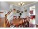 An ample dining room is showcased with dark wood table and stairs leading to the second level of the home at 3101 Woodhaven Way, Bargersville, IN 46106
