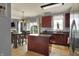 Open concept kitchen with dark cabinets, a kitchen island and an adjacent dining area at 3101 Woodhaven Way, Bargersville, IN 46106