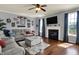 Cozy living room showcasing a fireplace, large windows, hardwood floors, and a comfortable gray sofa at 3101 Woodhaven Way, Bargersville, IN 46106