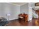 Open-concept living room with hardwood floors and piano next to staircase and french doors at 3101 Woodhaven Way, Bargersville, IN 46106