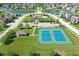 Aerial view of tennis courts and recreation lawn surrounded by upscale homes and lush landscaping with a lake in the background at 3101 Woodhaven Way, Bargersville, IN 46106
