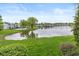 Picturesque lake view featuring green lawns, mature trees, and community pool at 3113 Sandpiper N Dr, Indianapolis, IN 46268