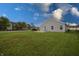 Backyard view of a home with a spacious lawn, small patio, and gray vinyl siding at 3367 Rolling Knoll Ln, Columbus, IN 47201