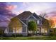 Two-story home with stone accents, gray siding, a well-kept lawn, mature trees, and a welcoming porch at sunset at 3561 Shady Lk Dr, Westfield, IN 46074