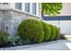 Landscaping with three round bushes, small blue flowers, decorative rock border, and a grey stone base at 3561 Shady Lk Dr, Westfield, IN 46074