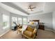 Bright main bedroom with a cozy sitting area, ceiling fan, and serene views from the large windows at 3561 Shady Lk Dr, Westfield, IN 46074