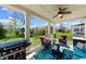 Covered porch with ceiling fan, comfortable seating, blackstone grill, and lovely view of backyard at 3561 Shady Lk Dr, Westfield, IN 46074