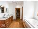 Bathroom featuring double sinks, granite countertops, and a separate soaking tub at 3948 S Woodfield Dr, New Palestine, IN 46163