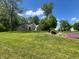 Expansive front lawn and well-manicured garden beds enhance the curb appeal of this charming residence at 3948 S Woodfield Dr, New Palestine, IN 46163