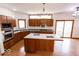 Open-concept kitchen with island, stainless steel appliances, and access to outdoor deck at 3948 S Woodfield Dr, New Palestine, IN 46163