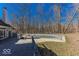 A large inground pool, surrounded by trees and a patio, offers a private outdoor retreat at 3948 S Woodfield Dr, New Palestine, IN 46163