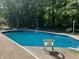 Backyard oasis with a refreshing pool surrounded by lush greenery, providing a private retreat at 3948 S Woodfield Dr, New Palestine, IN 46163